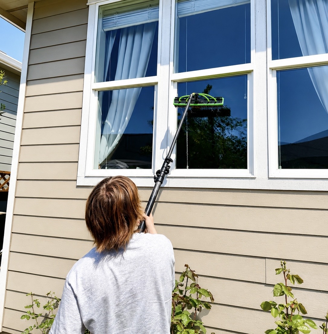 Careful pole cleaning of a wide white-trim upper window