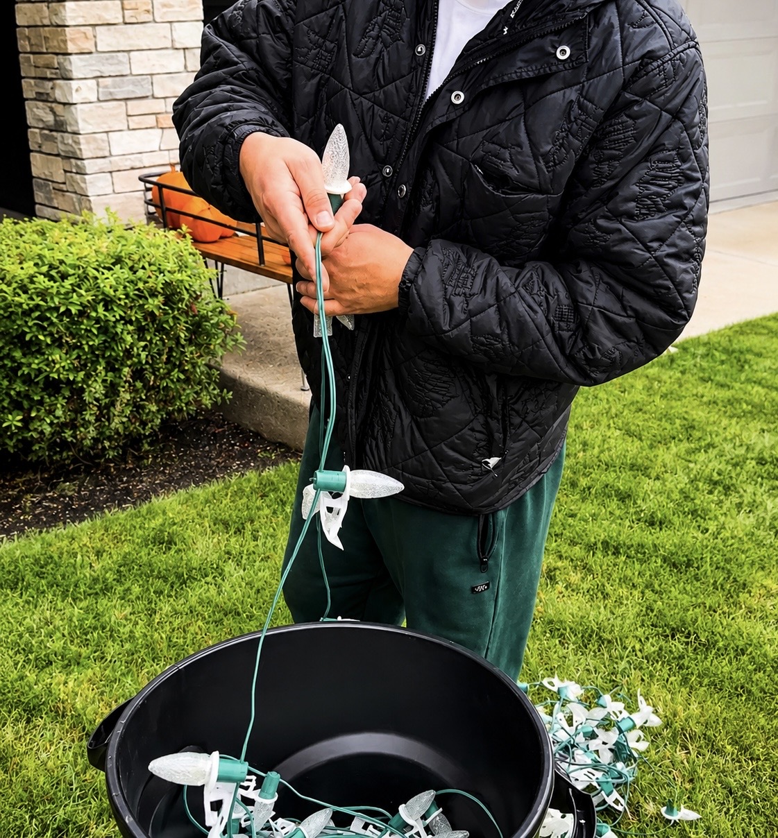 Close-up of a Halen Homes installer prepping commercial warm-white C9 Christmas bulbs