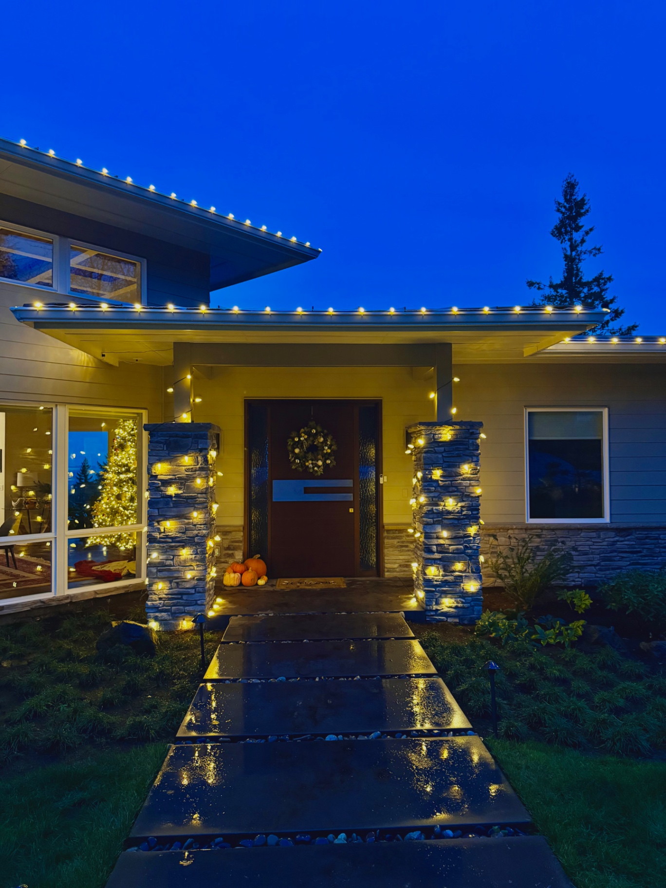 Close-up of professional warm white Christmas light bulbs clipped precisely along a home's gutter